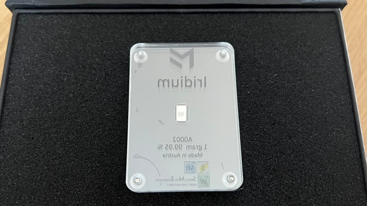 Iridium-Barren, ein Gramm, spiegelpoliert in durchsichtiger Acryl-Halterung mit MetaMetals-Logo auf der Vorderseite